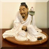 P03. Ceramic Asian ”Mud Man” holding a lotus. 8”h x 6.5”w - $42 